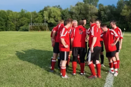 Football team huddling on a grassy field before a match