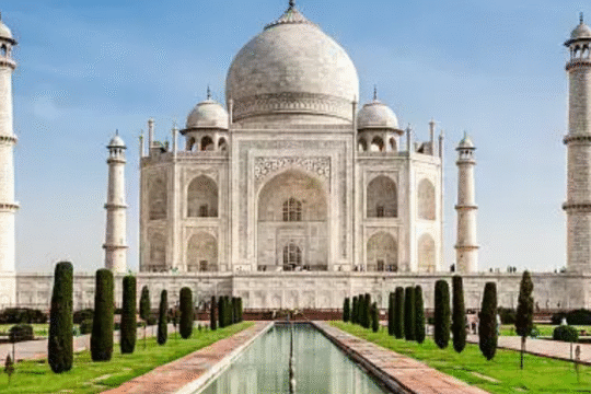 Front view of the iconic Taj Mahal with clear blue sky and reflecting pool in Agra, India.