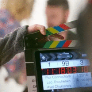 A film crew member holding a clapperboard during a movie shoot.