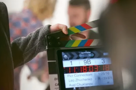 A film crew member holding a clapperboard during a movie shoot.