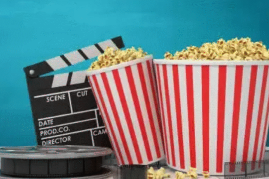 A popcorn bucket with the popcorn and film case.