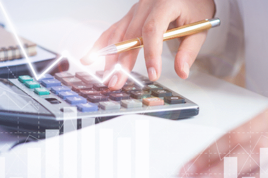 Businesswoman using a calculator with graphs and charts overlay, representing financial analysis and data calculation