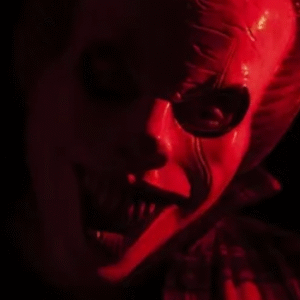 A scenic view of a modern passenger train traveling through a lush green landscape under a clear sky, with electric poles running alongside the tracks.