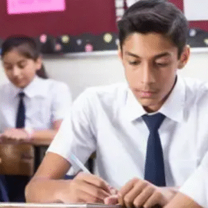 Group of Indian school students in uniform writing exams in a classroom setting.
