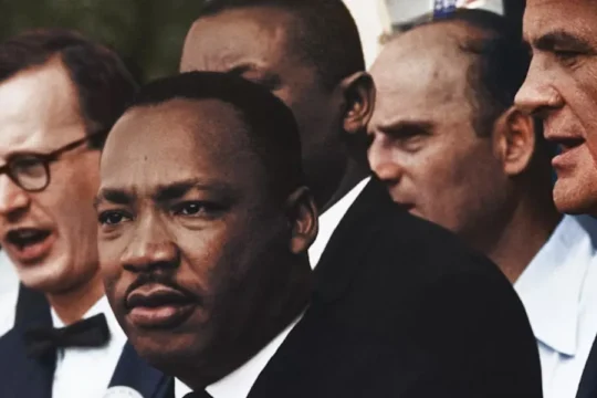 Dr. Martin Luther King Jr. is seen amidst a group of civil rights leaders at a rally