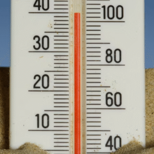A child sleeps on a woven mat, with a patterned cloth partially covering them.