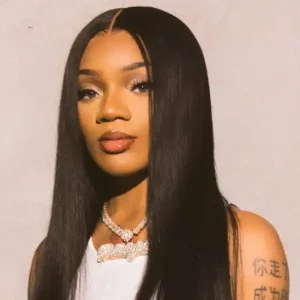 Suki Waterhouse in a white top, looking directly at the camera.