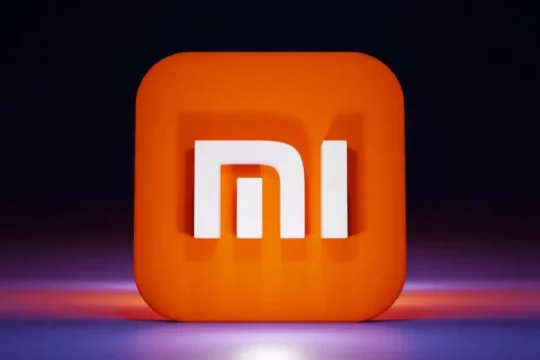 A glowing 3D Xiaomi (Mi) logo on a dark, reflective surface.