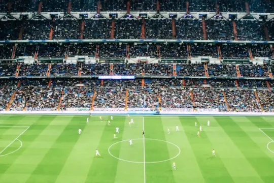 A night view of a fully packed football stadium during a match.