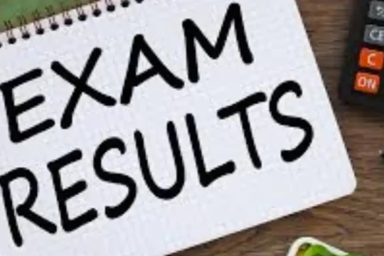 Notepad with "EXAM RESULTS" written, next to a calculator and pen.