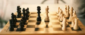 A chess board with black and white pieces set up for play.c
