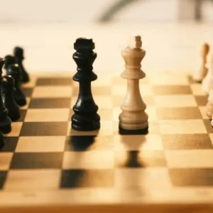 A chess board with black and white pieces set up for play.c