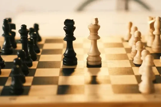 A chess board with black and white pieces set up for play.c