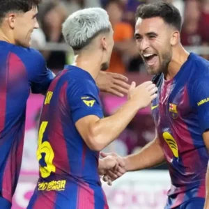 Football players in blue and red jerseys celebrating a goal