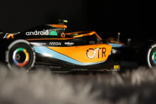 A detailed model of a black and orange McLaren Formula 1 car.