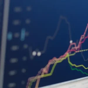 Close-up of a computer monitor displaying stock market charts with upward trends.