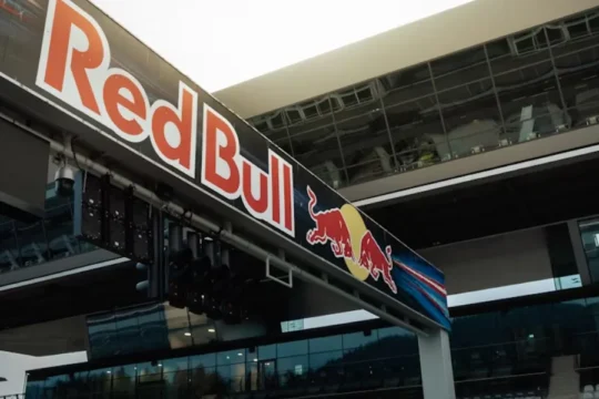 A large Red Bull banner with its logo prominently displayed at a race track.