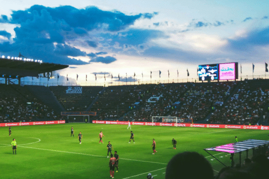 Panoramic view of a crowded football stadium at dusk.