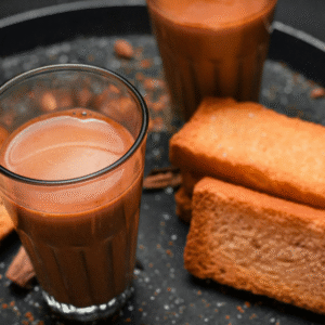 Glasses of chai tea with rusks on a dark tray.