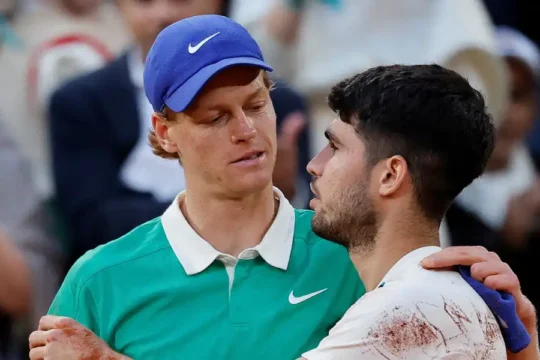 Jannik Sinner and Carlos Alcaraz embracing after a tennis match.