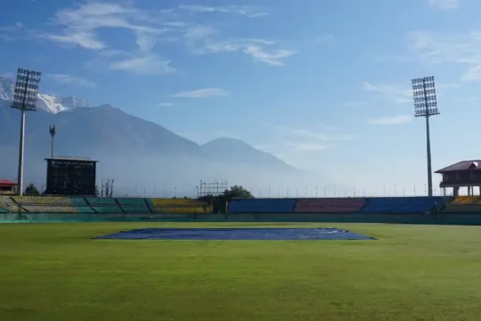 The scenic HPCA Stadium in Dharamshala, with snow-capped mountains in the background.