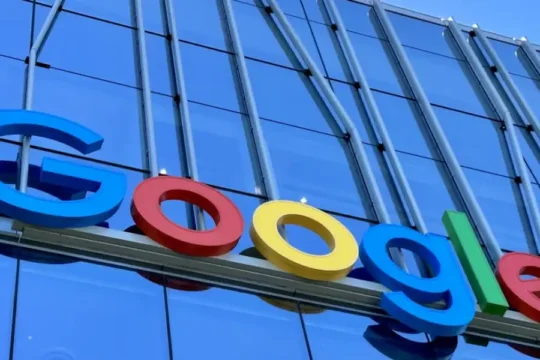 Large, colorful "Google" logo affixed to a modern glass building.