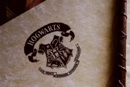 A close-up of a document featuring the Hogwarts crest with "HOGWARTS" written above it.