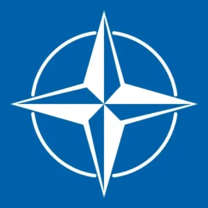 The NATO flag, featuring a white compass rose emblem on a dark blue field with four white lines emanating horizontally.