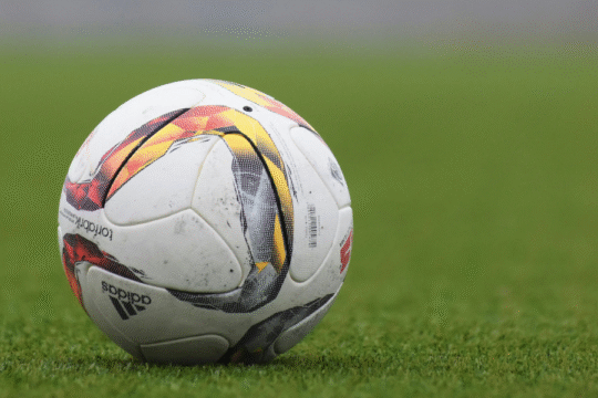 White soccer ball with colorful designs on green grass