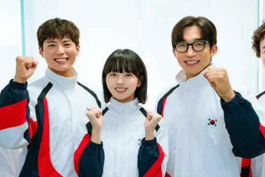 Five people in white, red, and blue jackets with South Korean flags pose, flexing.