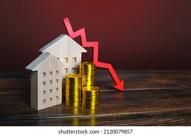 Wooden house model, coin stacks, and downward red arrow.