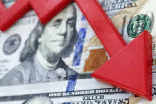 Red downward arrow over US dollar bills symbolizing economic decline or currency depreciation