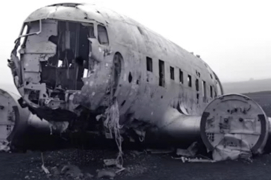 Abandoned and damaged aircraft fuselage wreck on desolate landscape