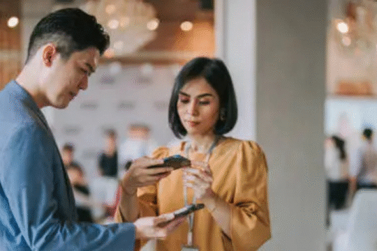 Man and woman exploring smartphone features at tech event or product launch