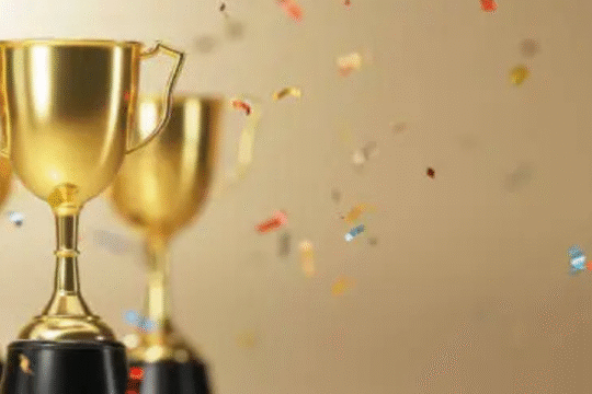 Golden trophies with falling confetti symbolizing celebration and achievement