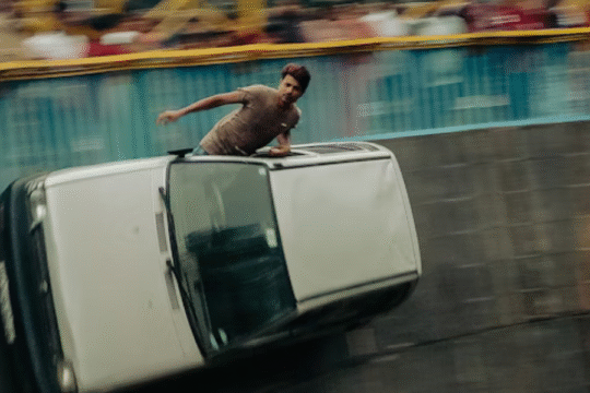 Man performing stunt in car on vertical wall