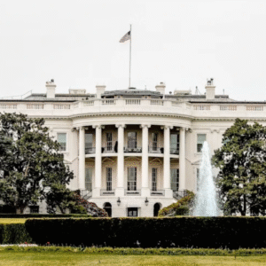 The White House, Washington D.C., surrounded by lush trees and a fountain in the foreground