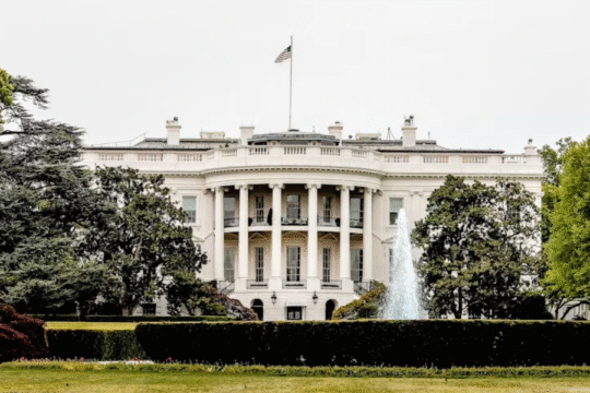The White House, Washington D.C., surrounded by lush trees and a fountain in the foreground
