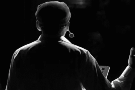 Silhouette of a speaker on stage wearing a headset microphone.