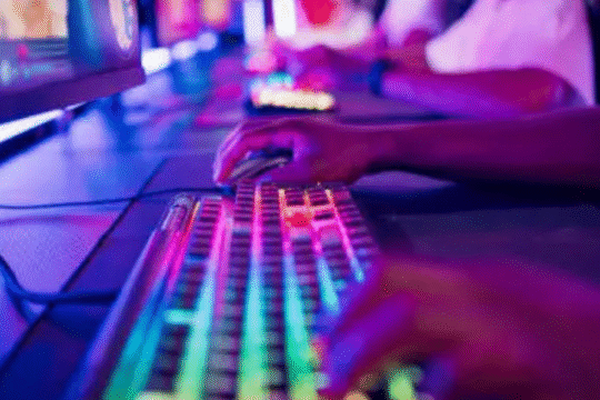 Gamers playing on RGB mechanical keyboards in a neon-lit gaming arena