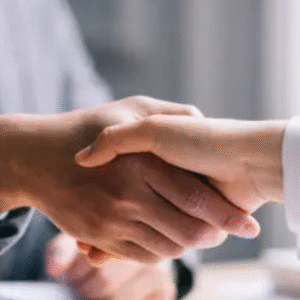 Close-up of a business handshake between two professionals in formal attire, symbolizing partnership or agreement.