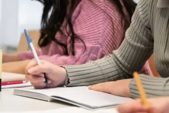 Students writing in notebooks during a classroom session