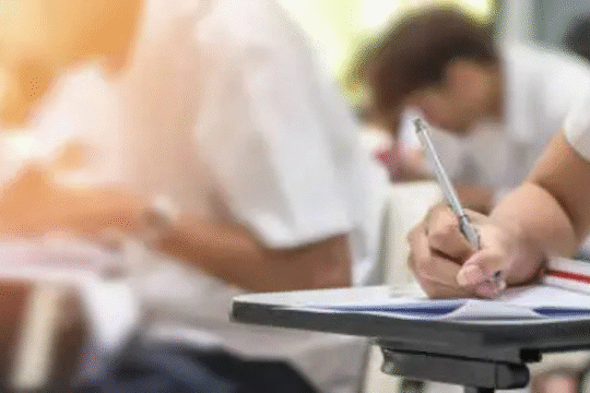 Students writing exams in a classroom with focused atmosphere