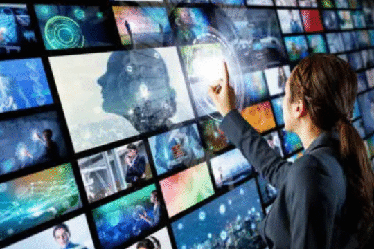 Woman interacting with a futuristic digital screen wall filled with multimedia content.