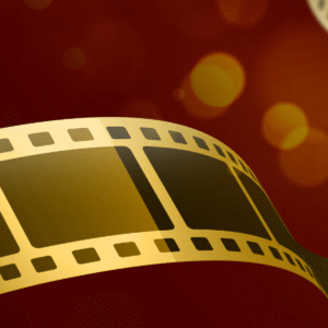 Golden film strips swirling over a red and orange bokeh background