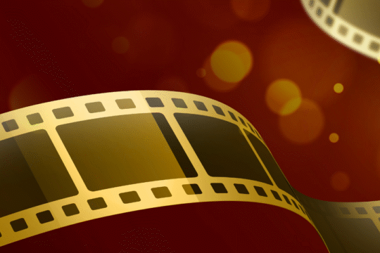 Golden film strips swirling over a red and orange bokeh background