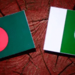 Flags of Bangladesh and Pakistan placed side by side on a wooden background, symbolizing a cricket rivalry or diplomatic relationship.