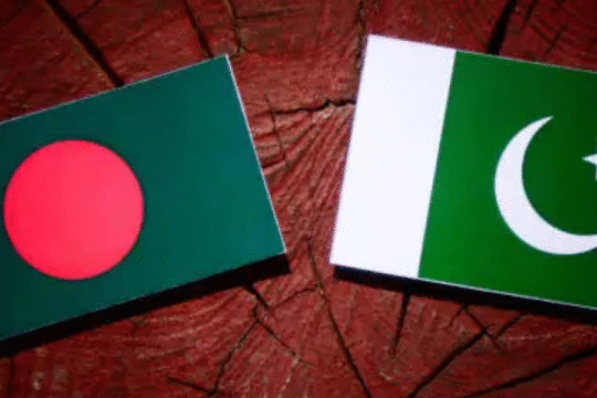 Flags of Bangladesh and Pakistan placed side by side on a wooden background, symbolizing a cricket rivalry or diplomatic relationship.