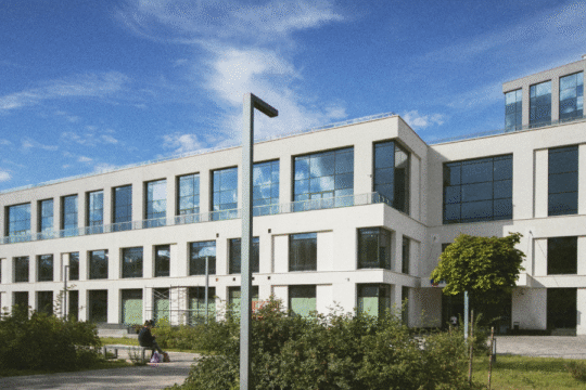 Modern white academic building with glass windows on a sunny day