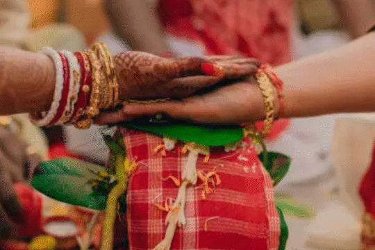 Close-up of hands of bride and groom during a traditional Indian wedding ritual.